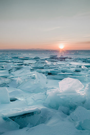 Scenic view of frozen sea against sky during sunset