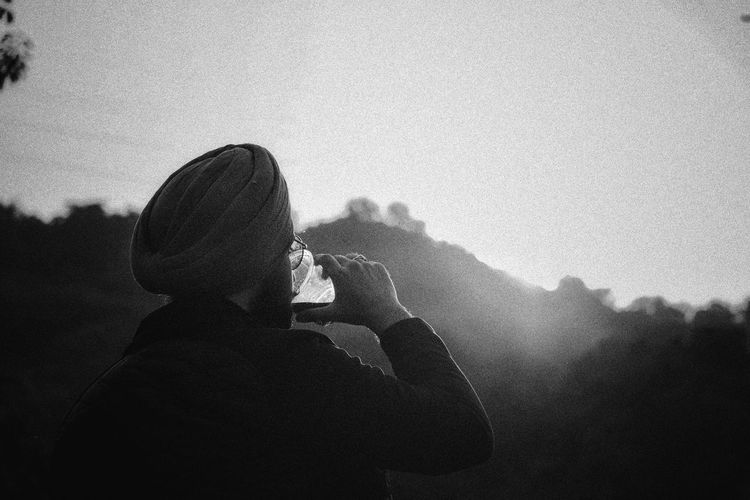 Portrait of man photographing against sky during foggy weather