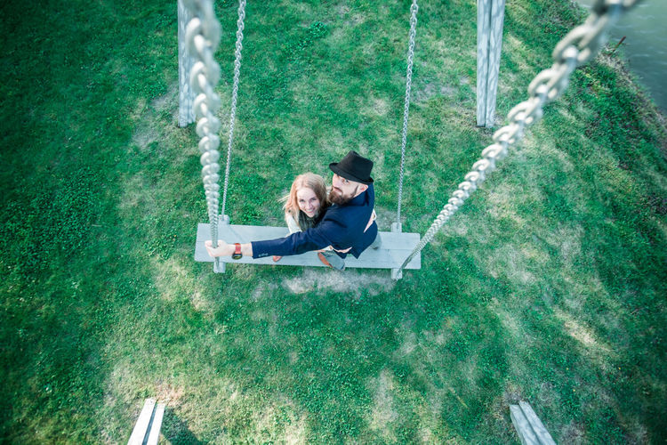 High angle view of couple standing on swing at park