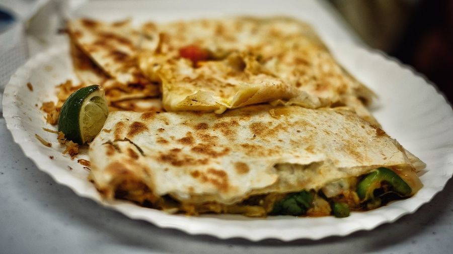 Close-up of fresh quesadilla with lemon piece served in plate