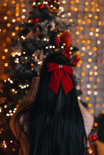 Rear view of woman with christmas tree