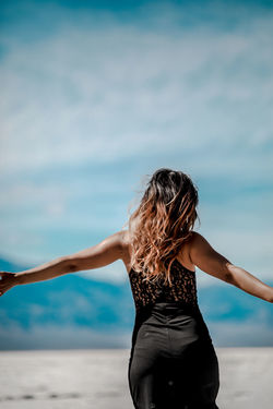 Rear view of woman standing against sky