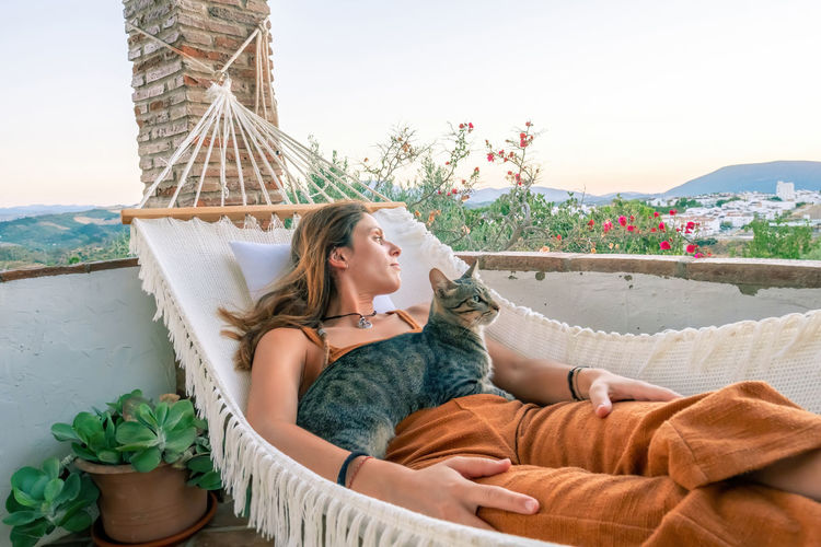 Side view of woman relaxing on hammock