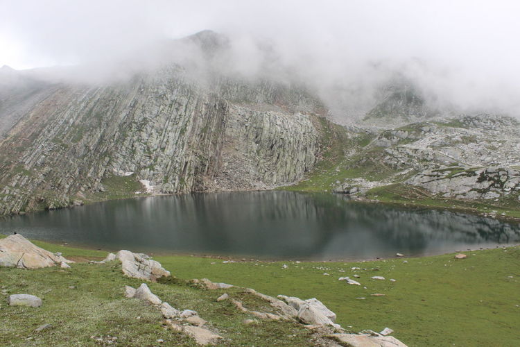 Scenic view of choharnag lake by mountain against sky at an elevation of 14,000ft.asl 