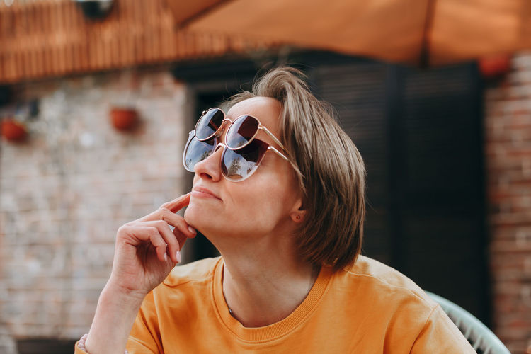 Smiling woman wearing various sunglasses