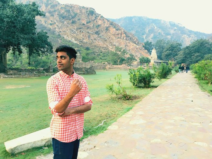 Young man standing on footpath at bhangarh fort