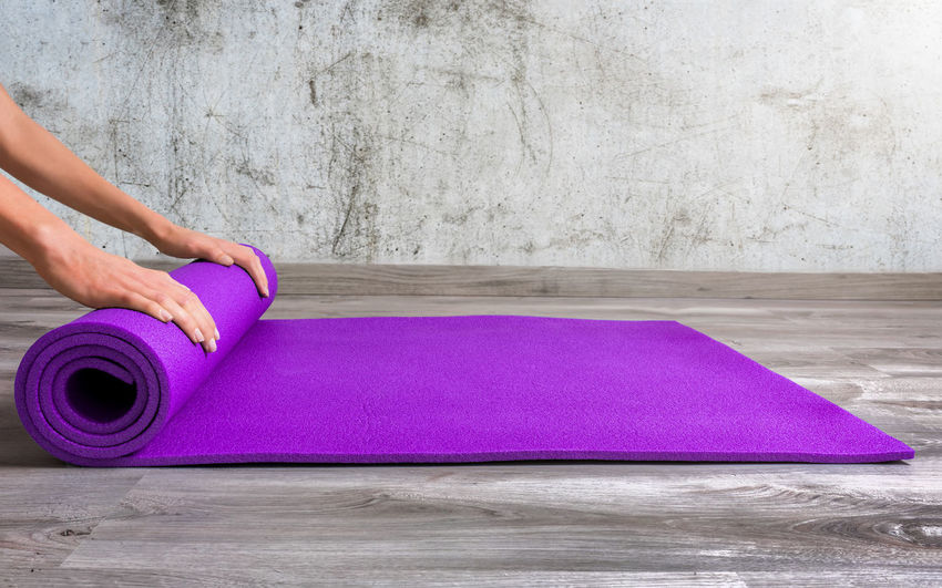 Low section of person rolling yoga mat