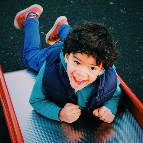 High angle view of happy boy on slide
