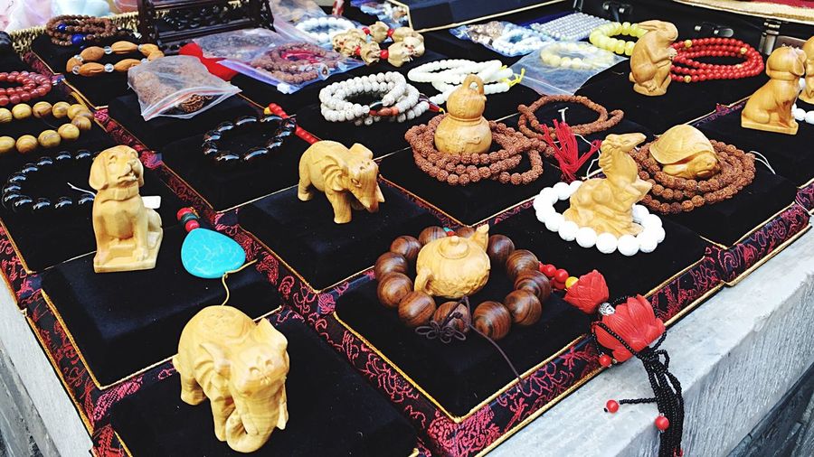 High angle view of figurines and bracelets for sale at market stall