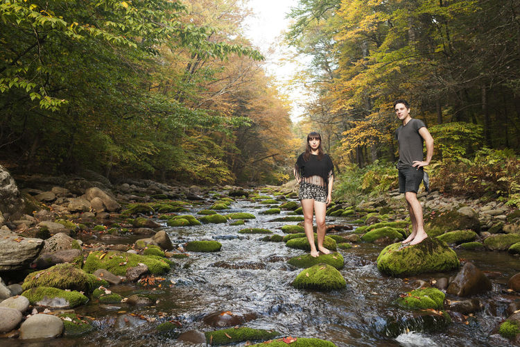 Young couple standing in a mossy stream