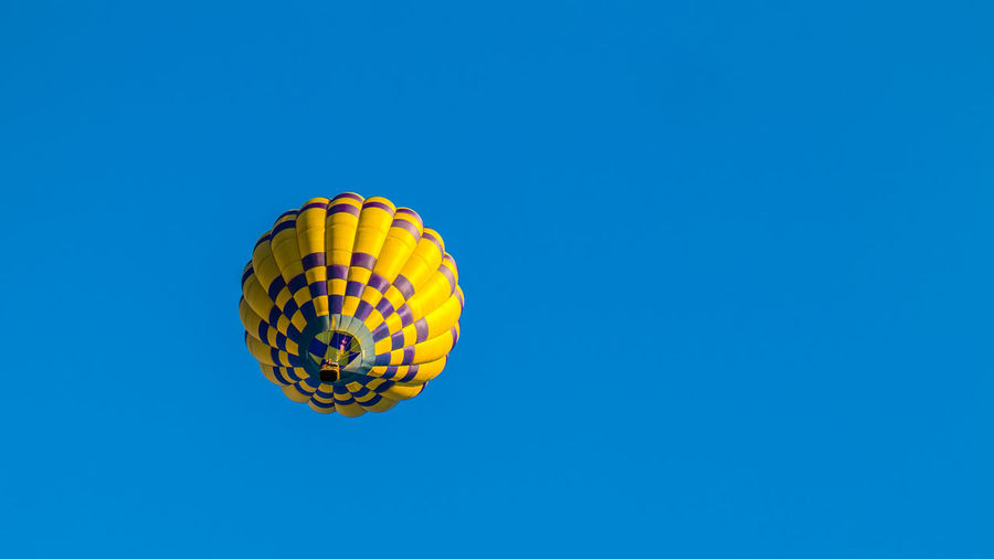 Low angle view of hot air balloons against blue sky