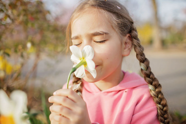 Cute girl smelling flower