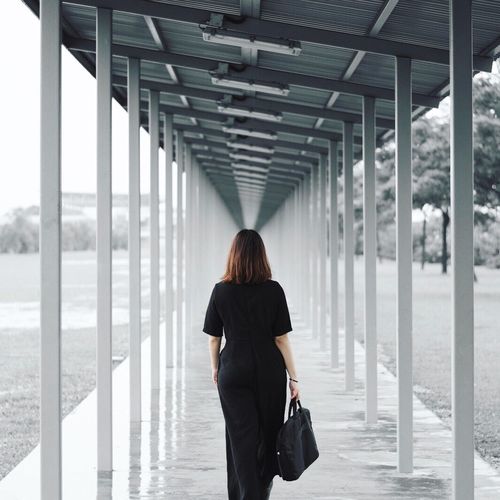 Rear view of woman walking in walkway