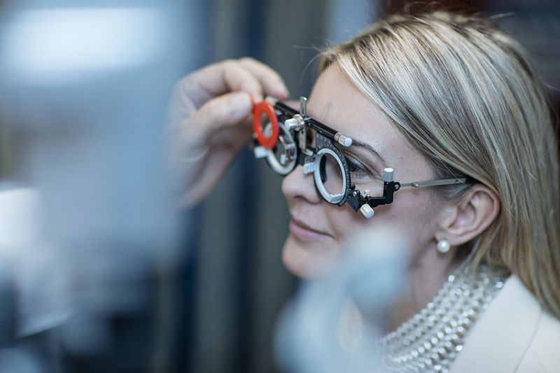 Optometrist adjusting test frame for patient