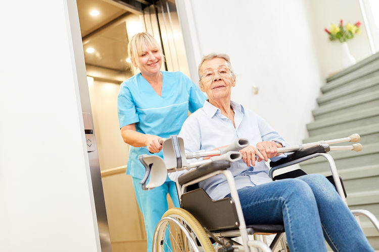 Nurse pushing patient in wheelchair at hospital