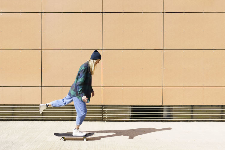 Young woman skateboarding during sunny day