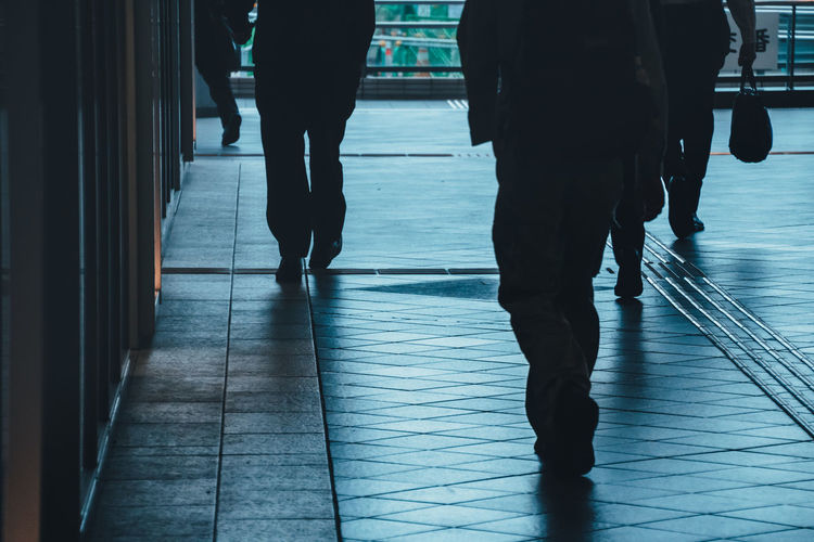 Low section of people walking on tiled floor