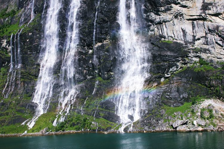 Majestic waterfall on rocky coastline in norway