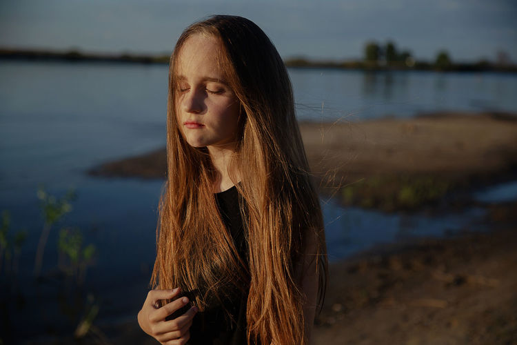 Teenage girl looking at lake