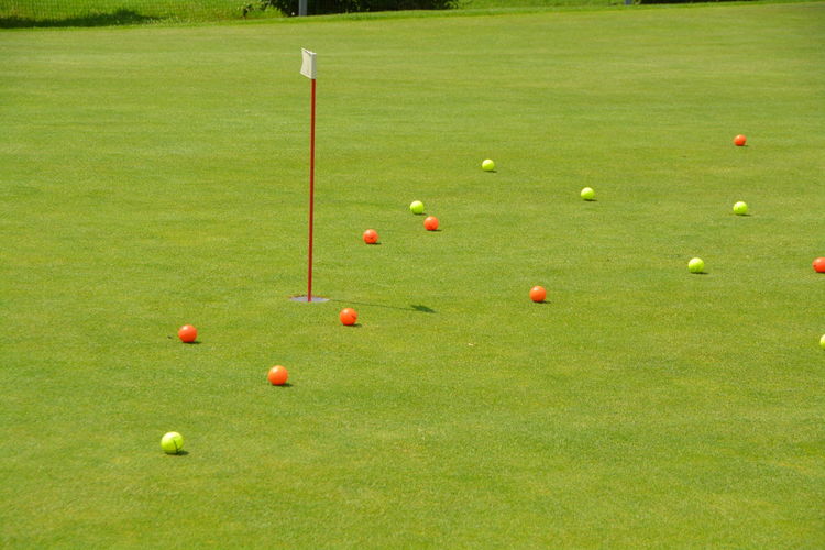 High angle view of golf balls by flag on course