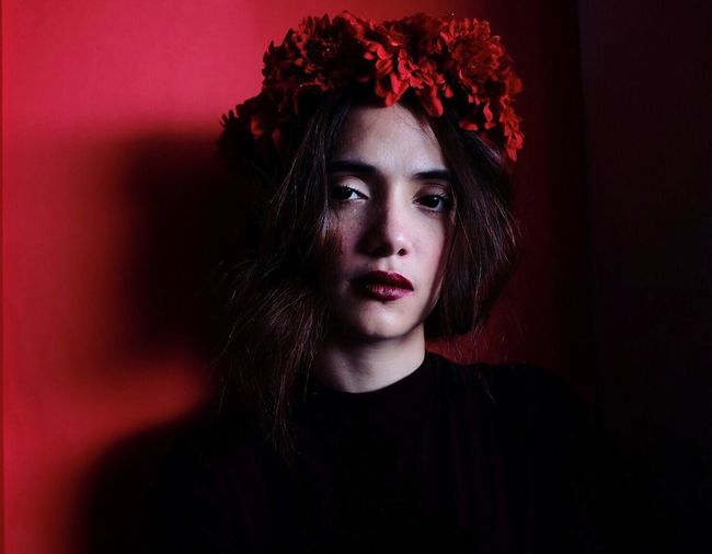 Portrait of young woman with red flower