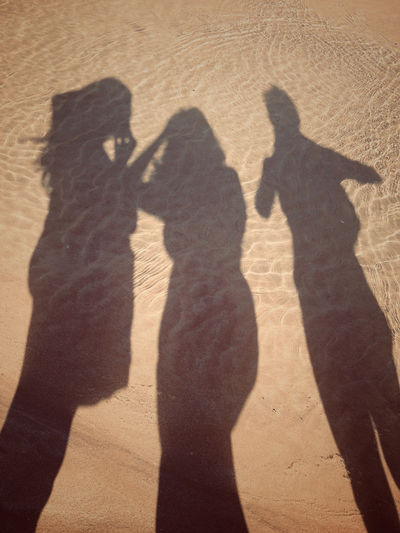 SHADOW OF PEOPLE ON THE BEACH