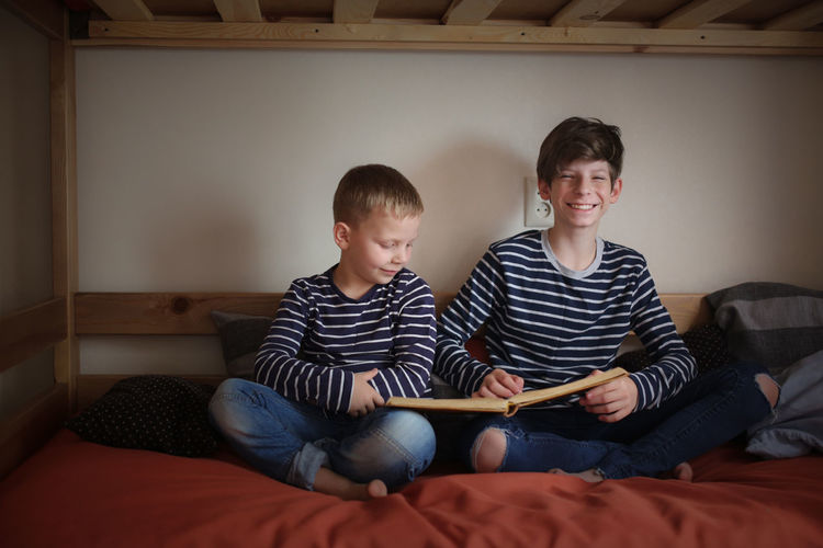 The brothers read together on two bunk beds in the nursery, the concept of kinship and childhood, 