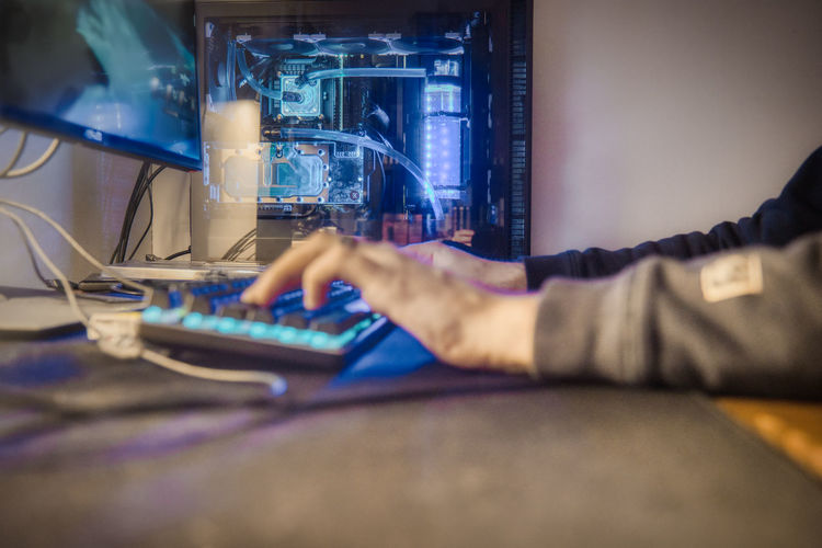 Man working by led light illuminated computer on table