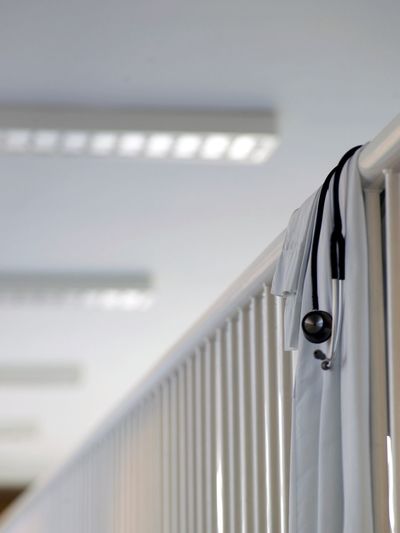 Lab coat and stethoscope on railing in hospital