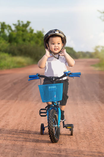 Portrait of boy riding bicycle on road
