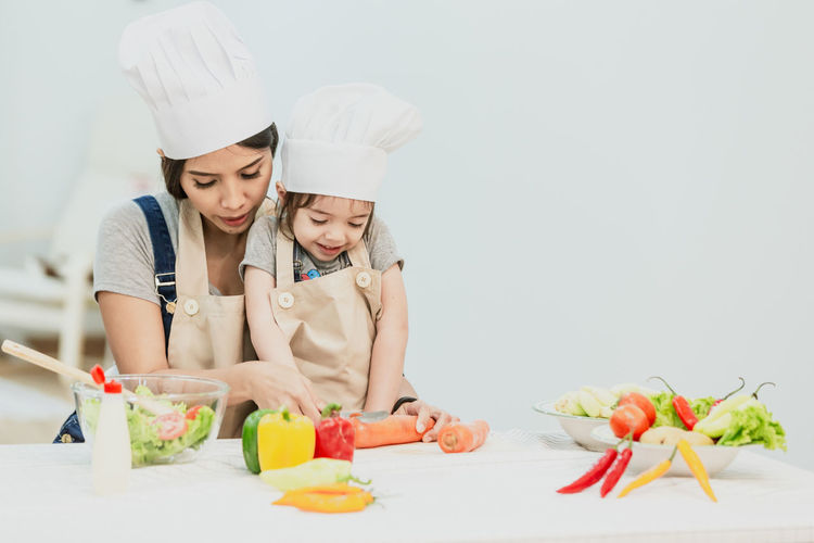 Full length of mother and daughter on table