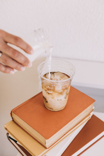 Midsection of woman holding drink on table