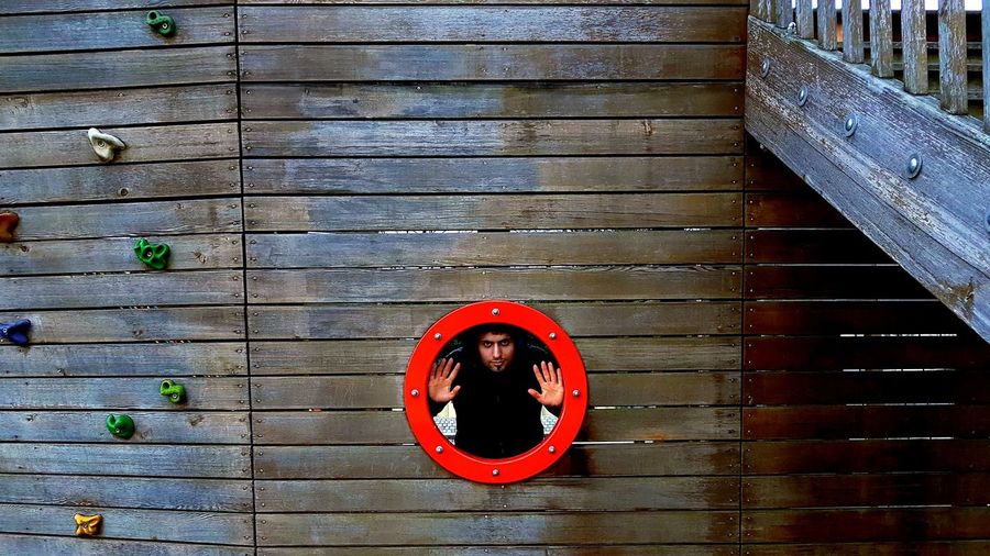 Portrait of young man looking through porthole