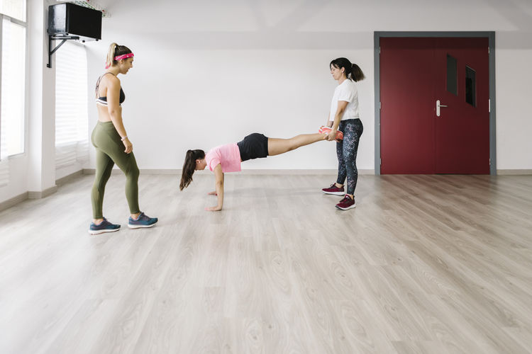 Woman and young girl doing push-ups in gym
