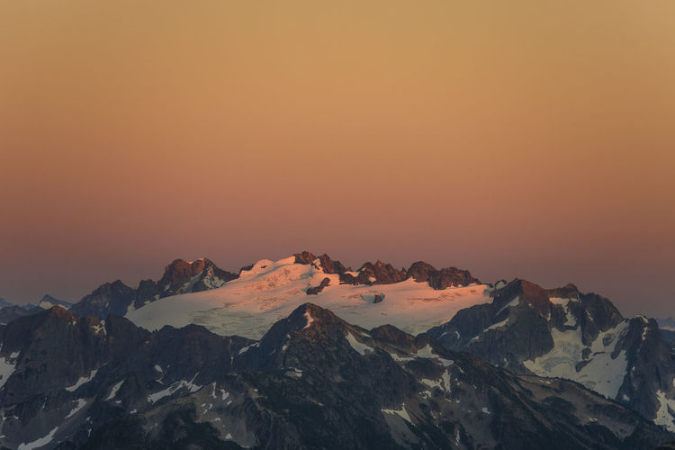 Alpenglow on glacier and mountain peaks, washington state, usa.