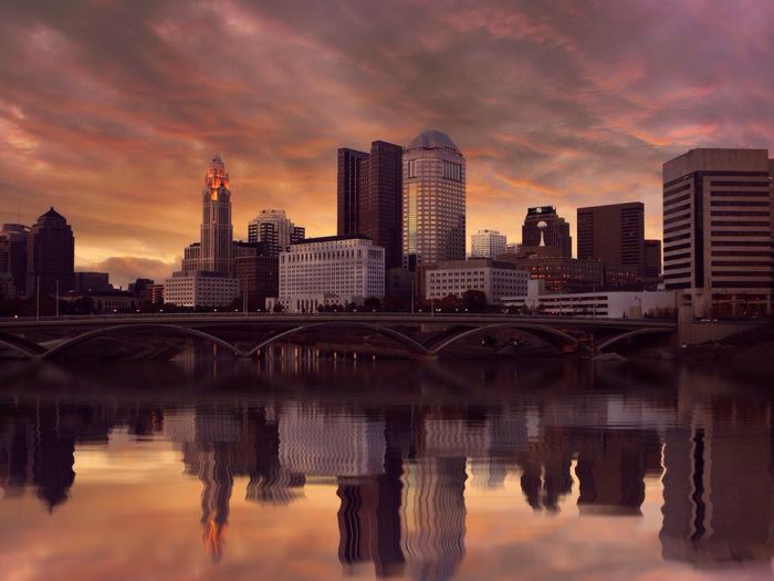 Sunset over river with buildings in background