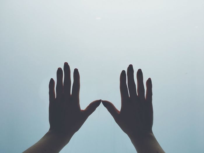 Close-up of hands against clear sky