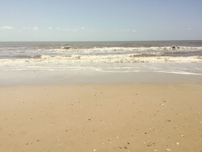 View of sandy beach against blue sky