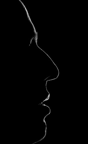 Close up of human face over black background
