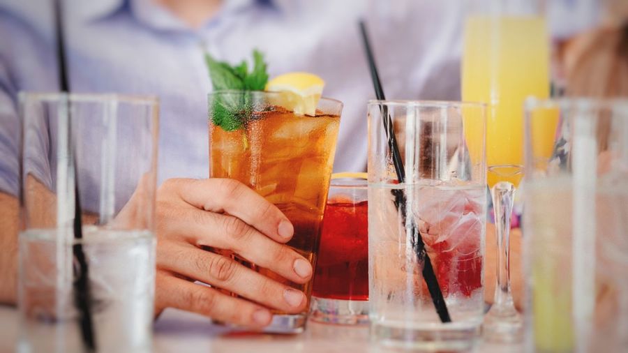 Midsection of man having drink at table