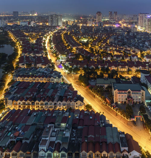 High angle view of illuminated street amidst buildings in city