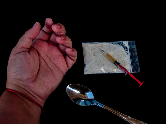 Cropped hand taking drugs at table