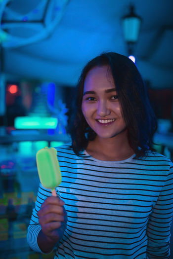 Cheerful optimistic asian girl with neon ice cream