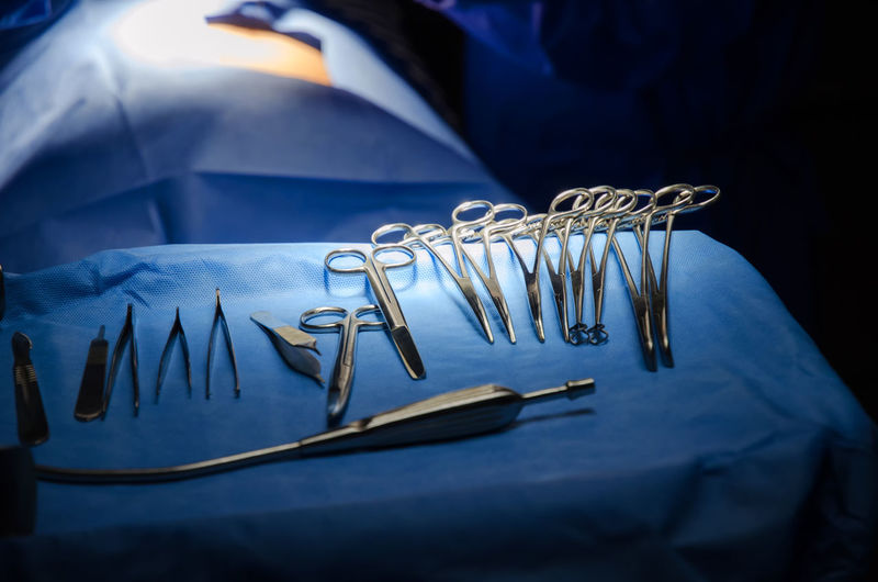 Close-up of surgical scissors on bed in operating room