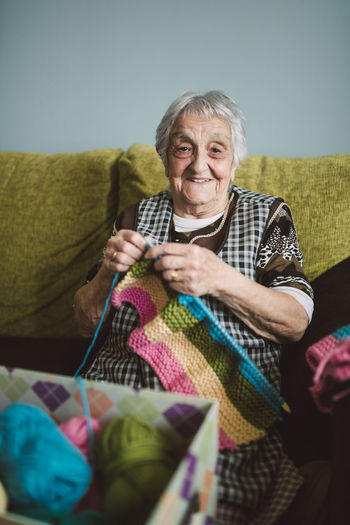 Portrait of smiling senior woman with knitting