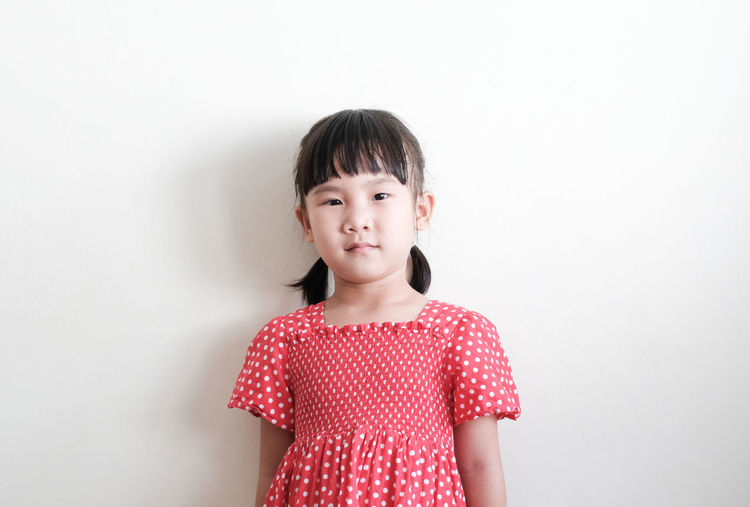 Portrait of a girl standing against white background