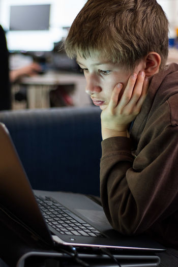 Close-up of boy using laptop