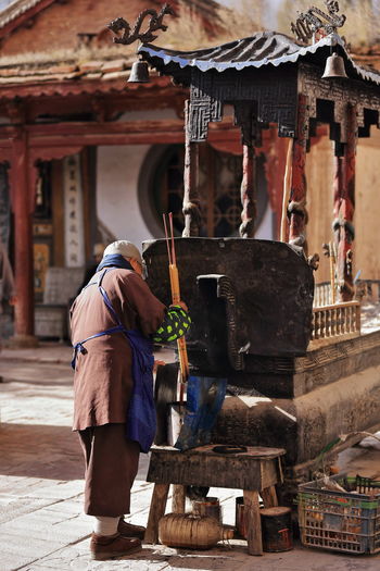 0921 zhangye, china. buddhist monk prepares big incense sticks. qianfo buddha grottoes-matisi temple