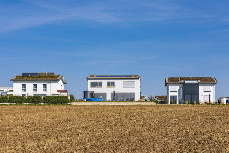 Germany, baden-wurttemberg, sindelfingen, field in front of modern suburban houses