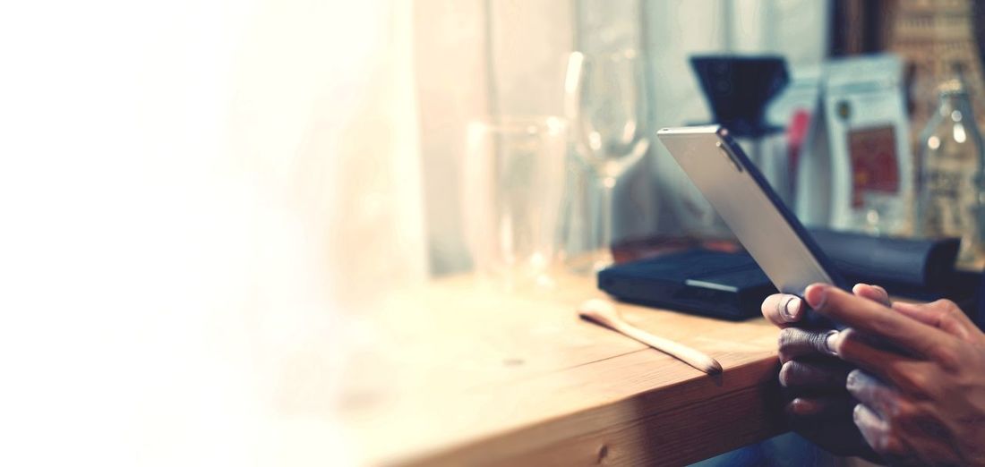 Business using tablet on wood table in cafe shop
